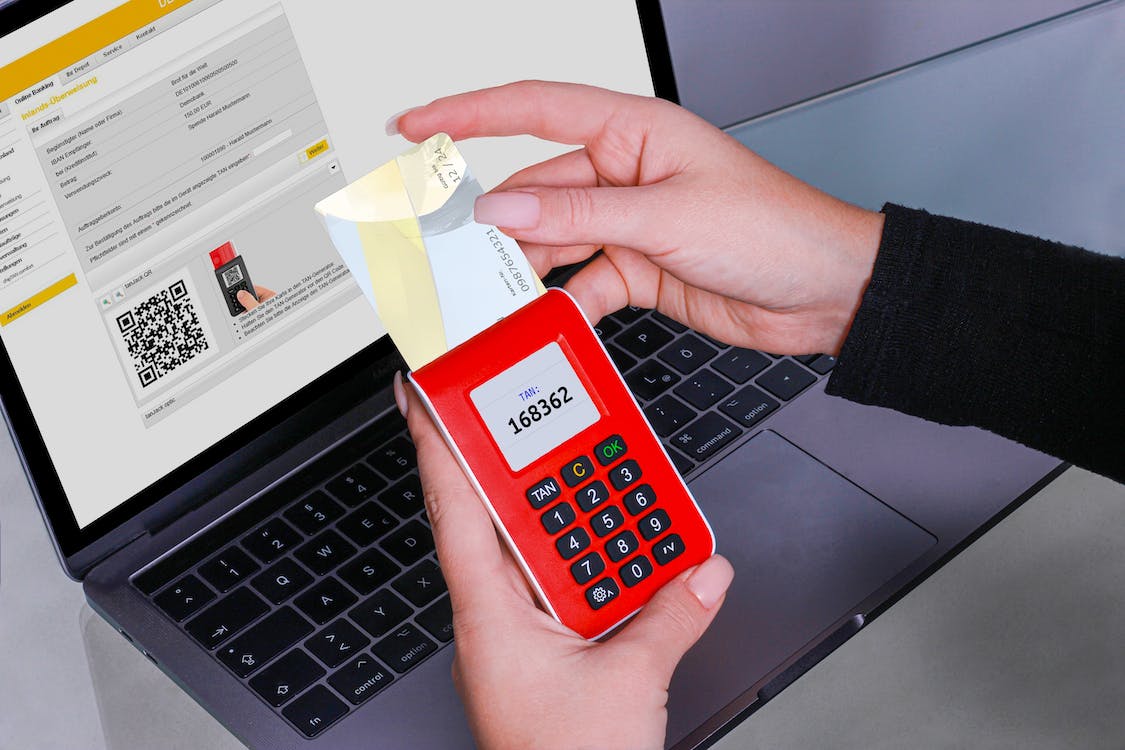 Free Person Holding Red Calculator Near Black Laptop Computer Stock Photo